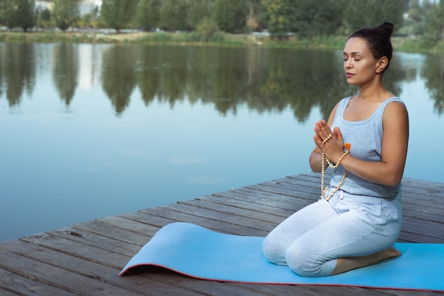 mujer joven, hacer, yoga, en el lago