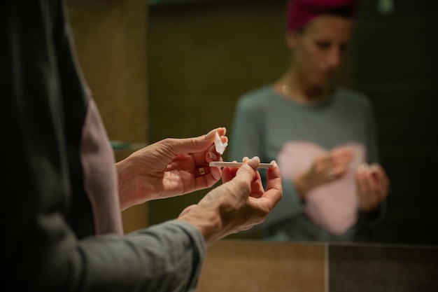 Mujer joven haciendo una autoprueba casera para coronavirus en una imagen conceptual de la nueva realidad.