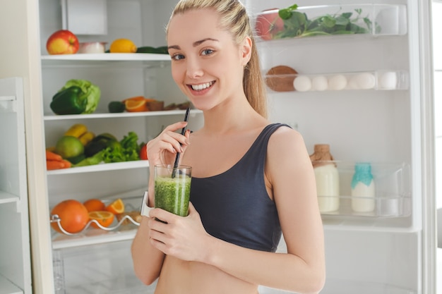 Mujer joven haciendo batido de desintoxicación en casa