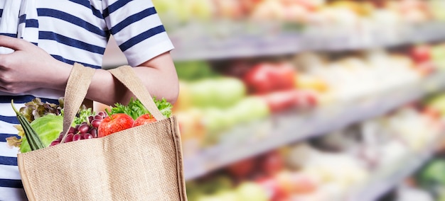 Foto la mujer joven está haciendo compras en el supermercado