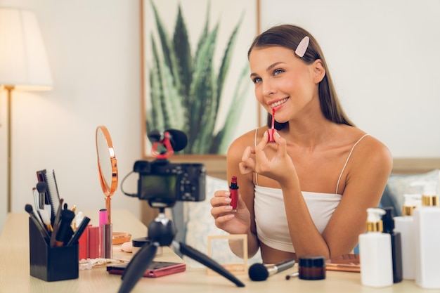 Mujer joven haciendo contenido de video tutorial de belleza y cosméticos Desvelando