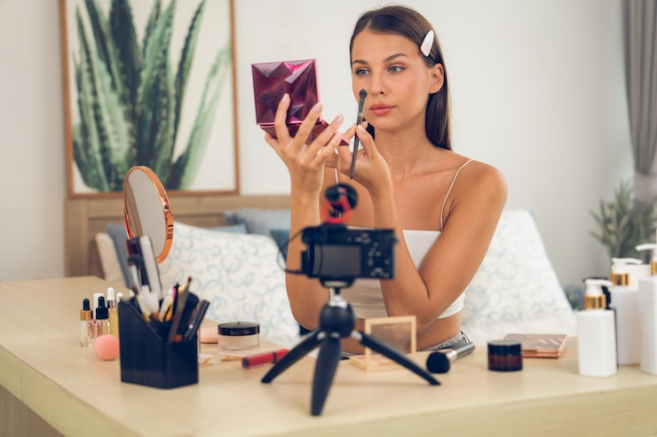 Foto mujer joven haciendo contenido de video tutorial de belleza y cosméticos desvelando