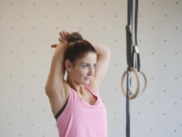 Mujer joven haciendo ejercicio en anillos de gimnasia