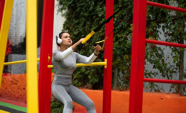 Mujer joven haciendo ejercicio con bucles atléticos