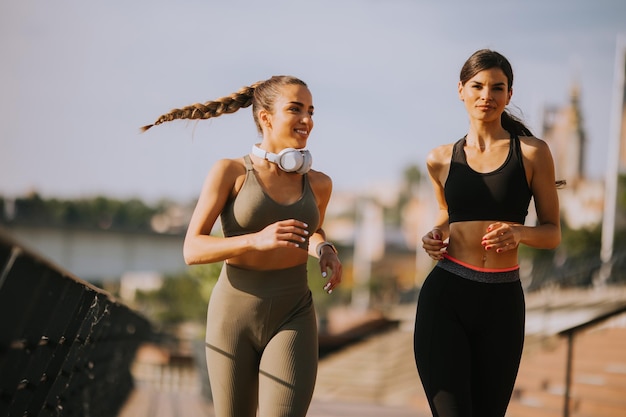 Mujer joven haciendo ejercicio corriendo por el paseo del río