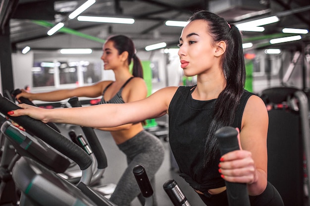 Mujer joven haciendo ejercicio en cross-trainer