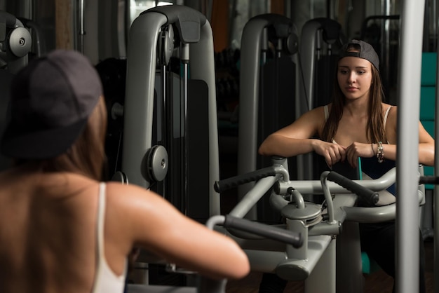 Mujer joven haciendo ejercicio de peso pesado para la espalda en el gimnasio