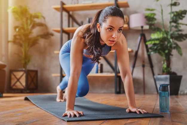 Mujer joven haciendo ejercicios deportivos en casa