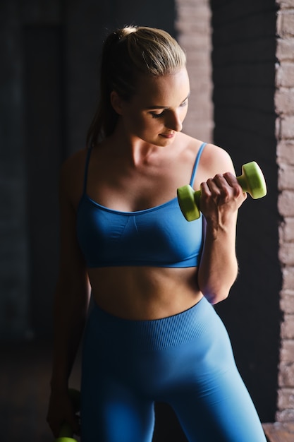 Mujer joven haciendo ejercicios deportivos en el gimnasio