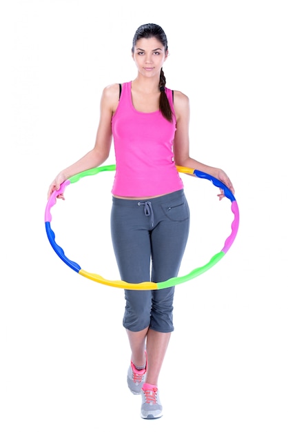 Mujer joven haciendo ejercicios con hula-hoop.