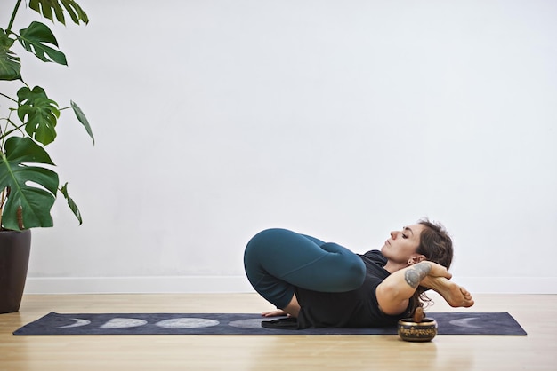 Mujer joven haciendo fitness en casa La niña practica deportes en una alfombra Mujer haciendo yoga