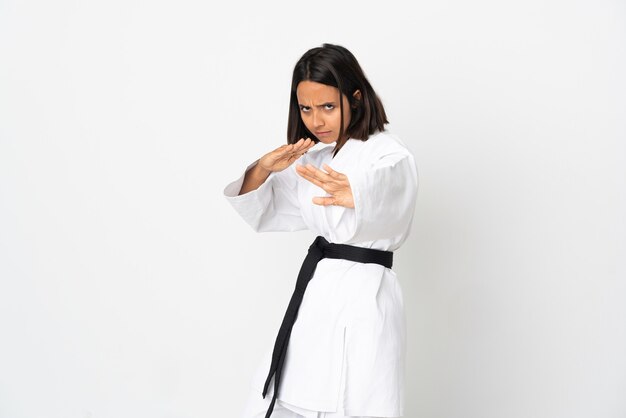 Mujer joven haciendo karate aislado sobre fondo blanco.