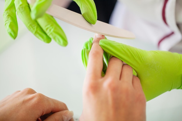 Mujer joven haciendo manicura en el salón