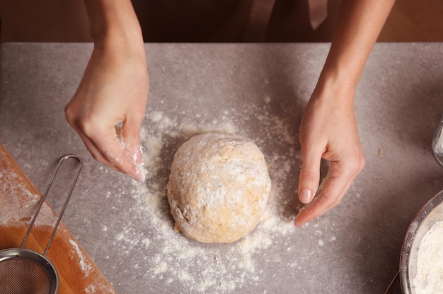 Foto mujer joven haciendo masa en la cocina