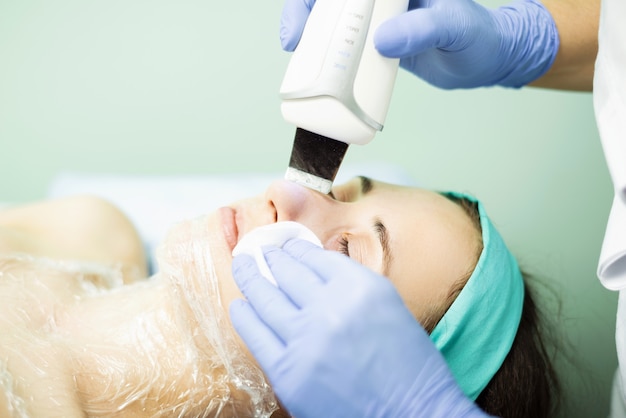 Mujer joven haciendo una mascarilla facial y relajante