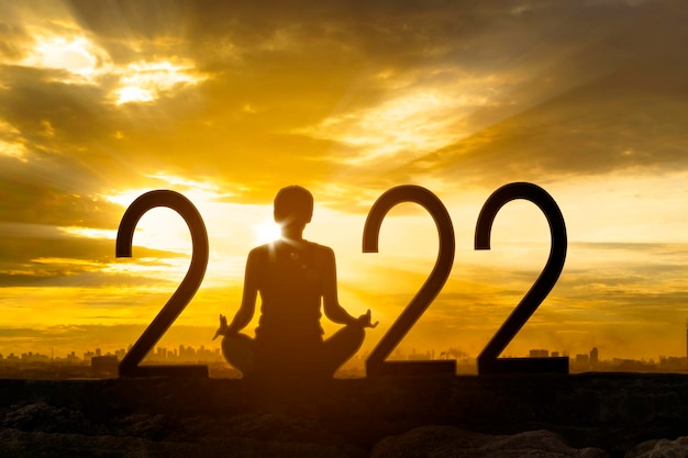 Mujer joven haciendo meditación con números 2022