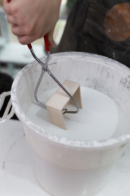 Mujer joven haciendo un molde de cerámica, en su taller.