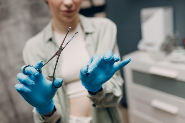 Mujer joven haciendo piercing en la oreja en el salón de belleza