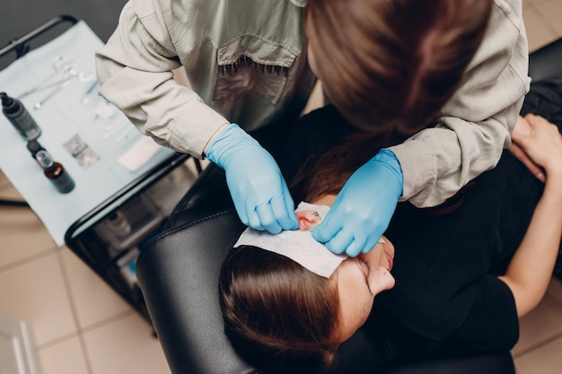 Mujer joven haciendo piercing en la oreja en el salón de belleza