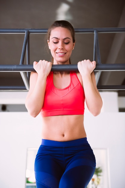 Foto mujer joven haciendo pull-ups