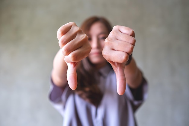 Una mujer joven haciendo la señal de los pulgares hacia abajo