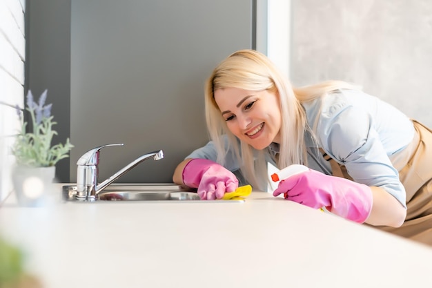 Mujer joven haciendo tareas domésticas, limpiando la cocina