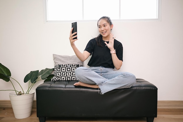 Mujer joven haciendo video vlog en casa usando su teléfono inteligente