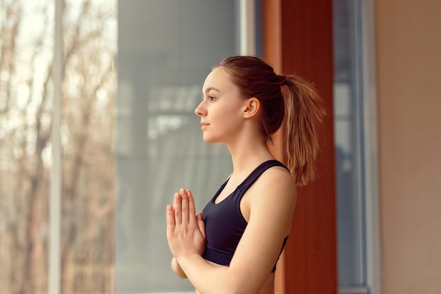 Mujer joven haciendo yoga en el gimnasio