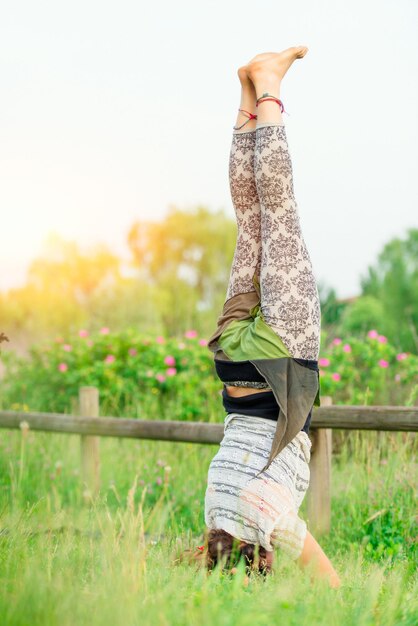 Mujer joven haciendo yoga en grupo en la mañana