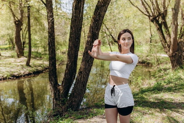 Mujer joven haciendo yoga en el parque de la mañana