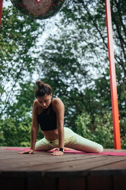 Foto una mujer joven haciendo yoga en el patio.