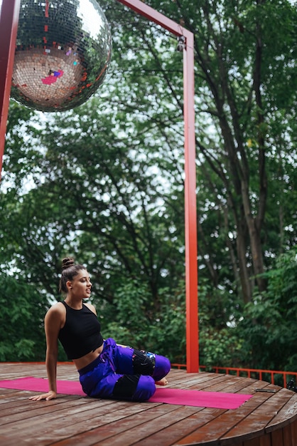 Una mujer joven haciendo yoga en el patio.