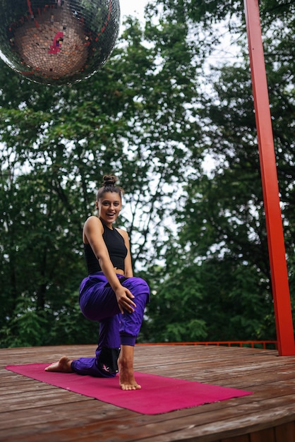 Una mujer joven haciendo yoga en el patio.