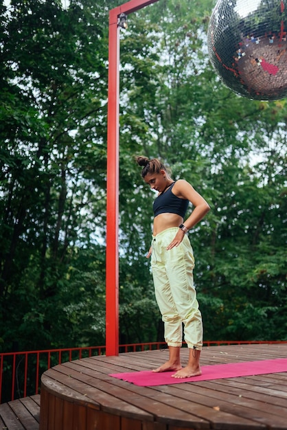 Una mujer joven haciendo yoga en el patio.