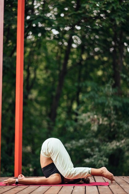 Una mujer joven haciendo yoga en el patio.