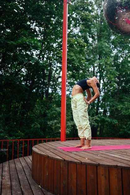 Una mujer joven haciendo yoga en el patio.