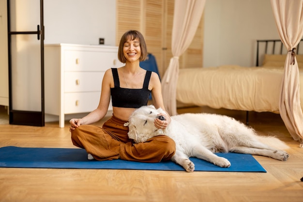 Mujer joven haciendo yoga con su perro