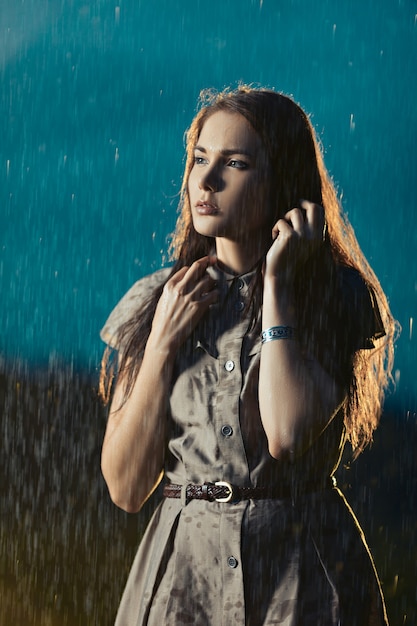 Mujer joven helada bajo la lluvia