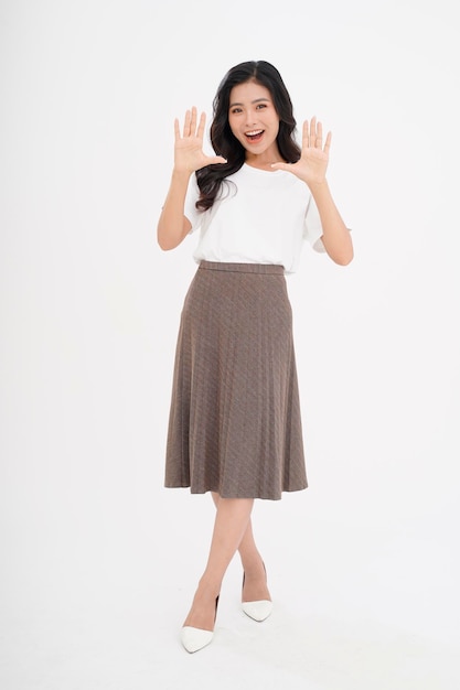 Mujer joven hermosa y atractiva asiática con gesto de mano mostrando con el dedo en el espacio de copia aislado en el fondo