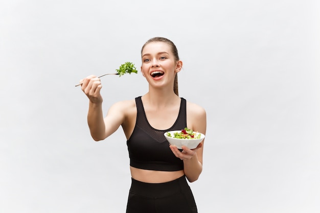 Mujer joven hermosa deporte comiendo ensalada