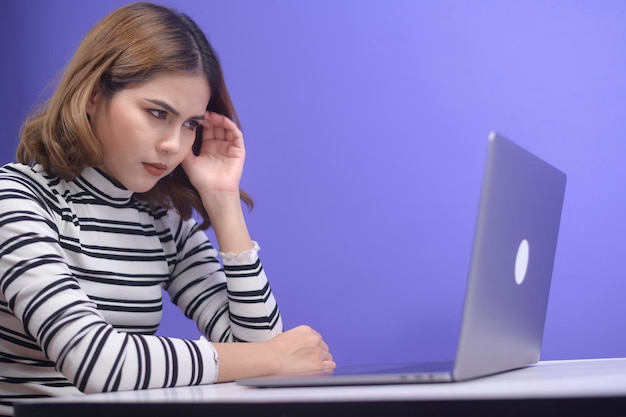 Una mujer joven y hermosa estresada sin trabajo por el fondo azul, el concepto de salud mental