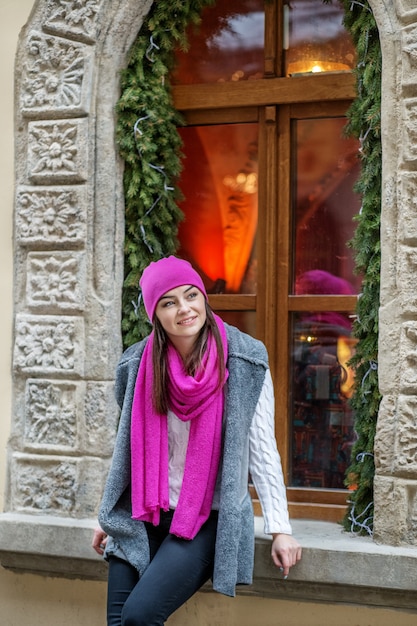 Mujer joven en la hermosa fachada de un café en la ciudad.