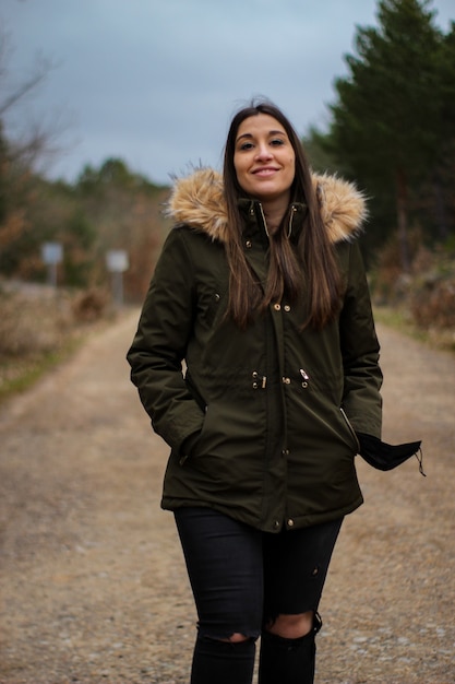 Mujer joven y hermosa feliz sonriendo en una excursión y caminar en un bosque