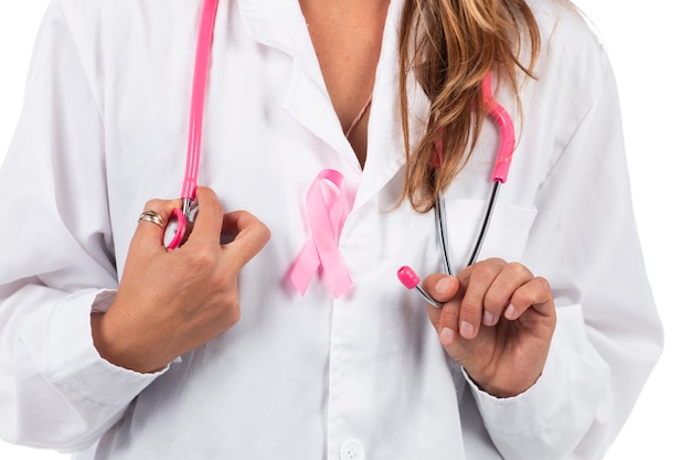 Mujer joven hermosa médico con estetoscopio rosa y cinta rosa de concienciación para el cáncer de mama