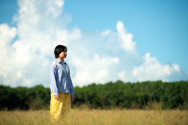 Mujer joven hermosa mujer feliz en la hermosa pradera en el fondo del cielo. concepto de felicidad.