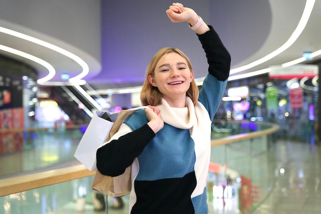 Mujer joven hermosa niña feliz con bolsas de compras en el centro comercial divirtiéndose comprar ropa