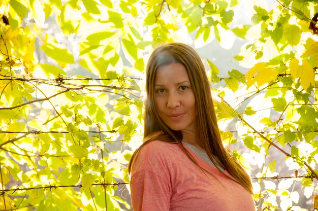 Mujer joven y hermosa en el parque de otoño brillante y colorido