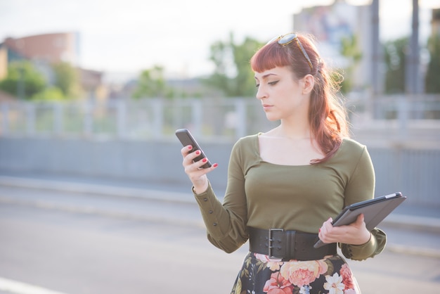 mujer joven hermosa pelirroja con smartphone