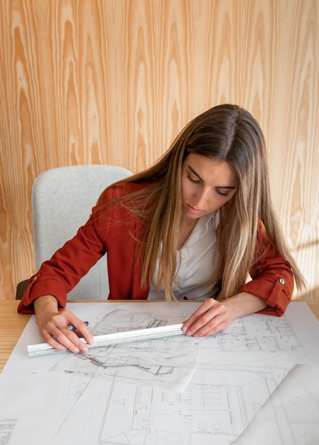 Mujer joven y hermosa que trabaja en proyecto arquitectónico