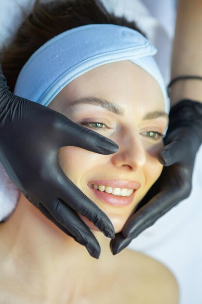 Mujer joven y hermosa recibiendo tratamiento facial en el salón de spa concepto de tratamiento de belleza